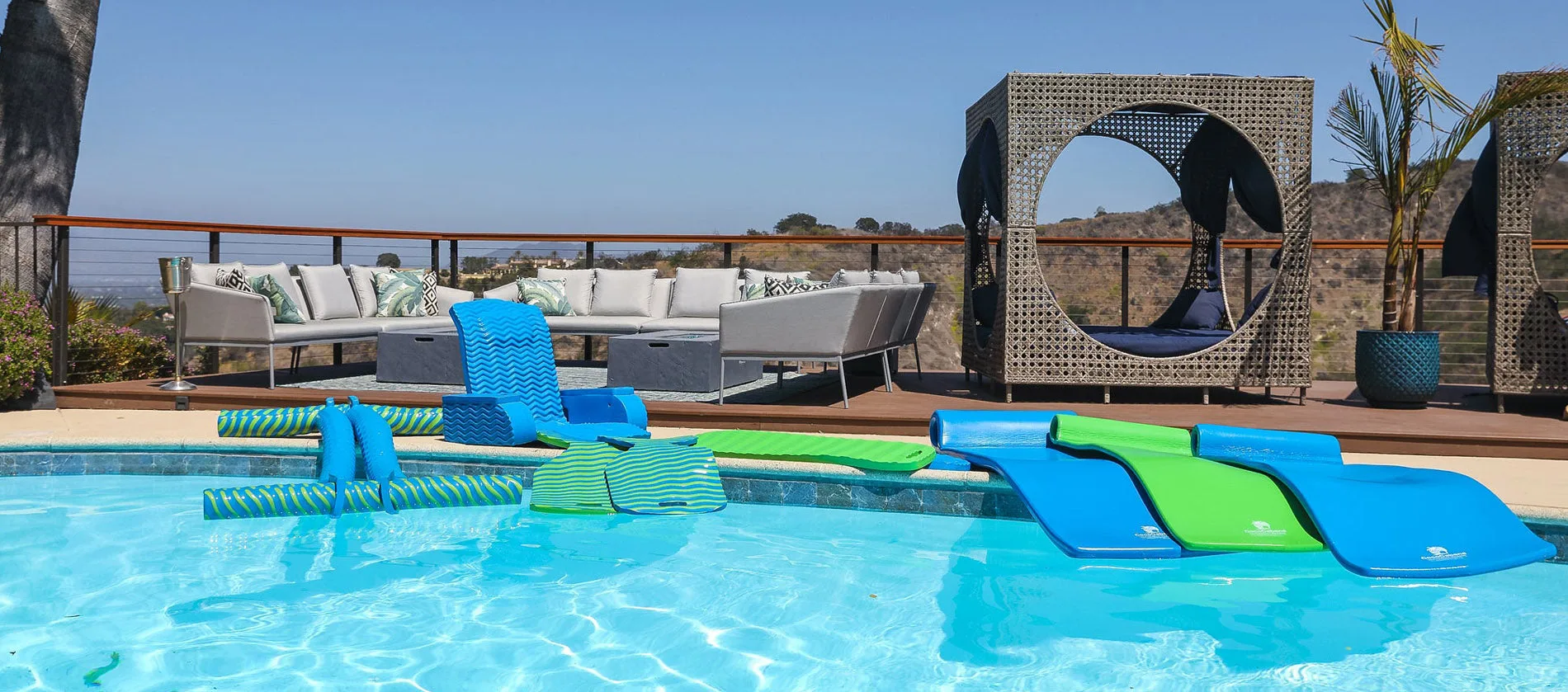 Woman relaxing on a Cococabana 74-inch striped blue and white foam pool float with headrest in a clear blue swimming pool